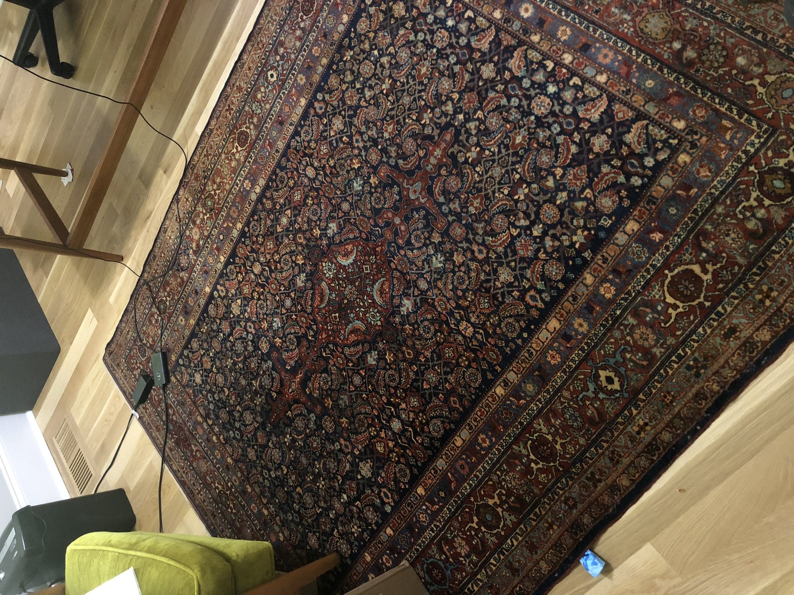 Antique Persian rug with an all-over herati design on a wood floor