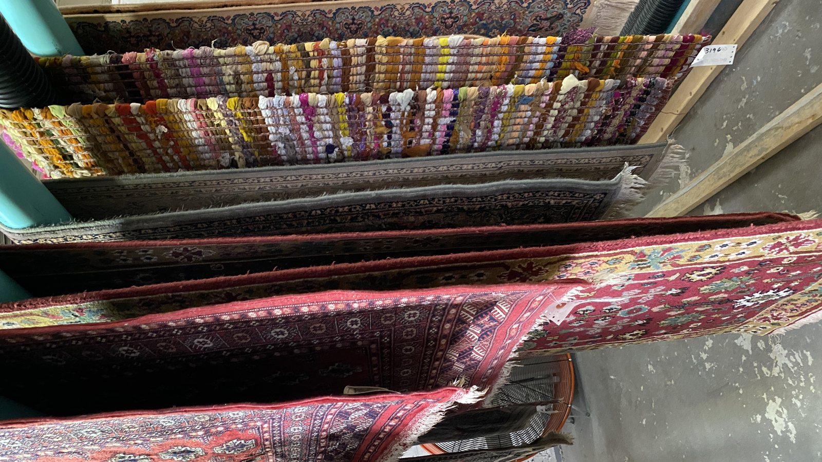 Washed rugs hanging over drying racks in the workshop
