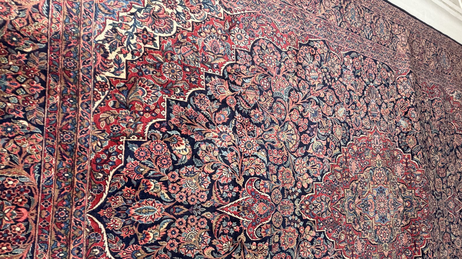 Antique Persian city rug showing dense floral field and central medallion