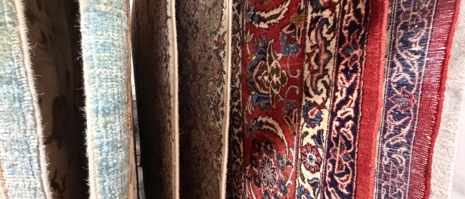Close view of stacked rug edges showing pile, selvedge and foundation