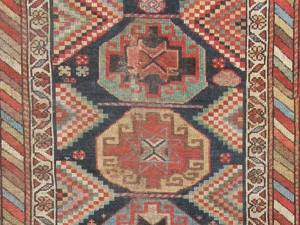 Caucasian rug with angular stepped medallions in red and indigo
